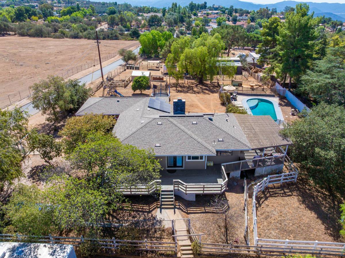 Overhead aerial showing the home, pool, animal areas, and open land