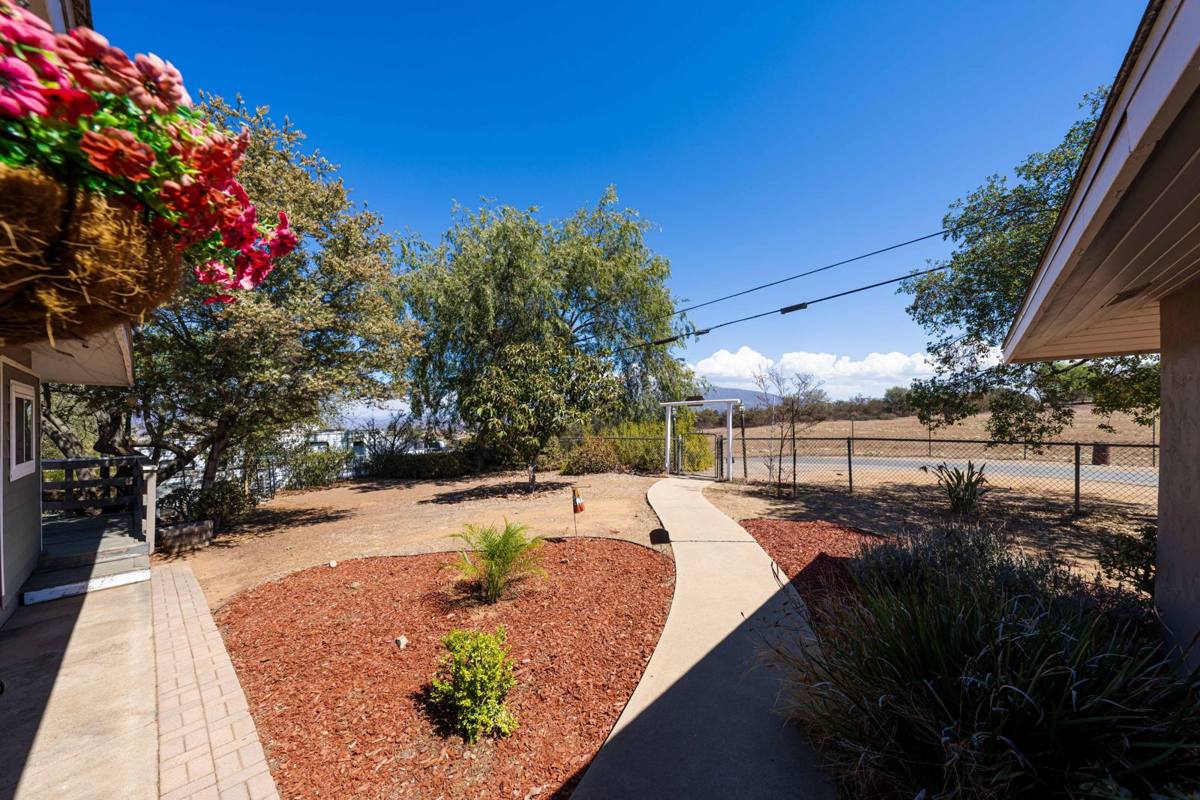 Front walkway leading to the gated entry with open land beyond