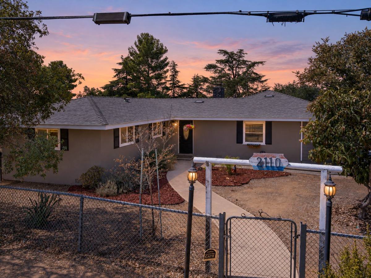 Gated front entry with lanterns and 2110 address sign